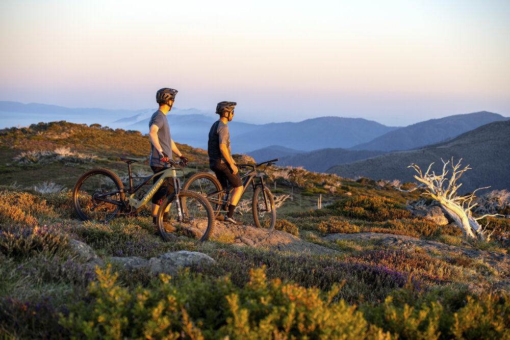 Zwei Personen genießen auf ihren Fahrrädern die Aussicht über die Landschaft