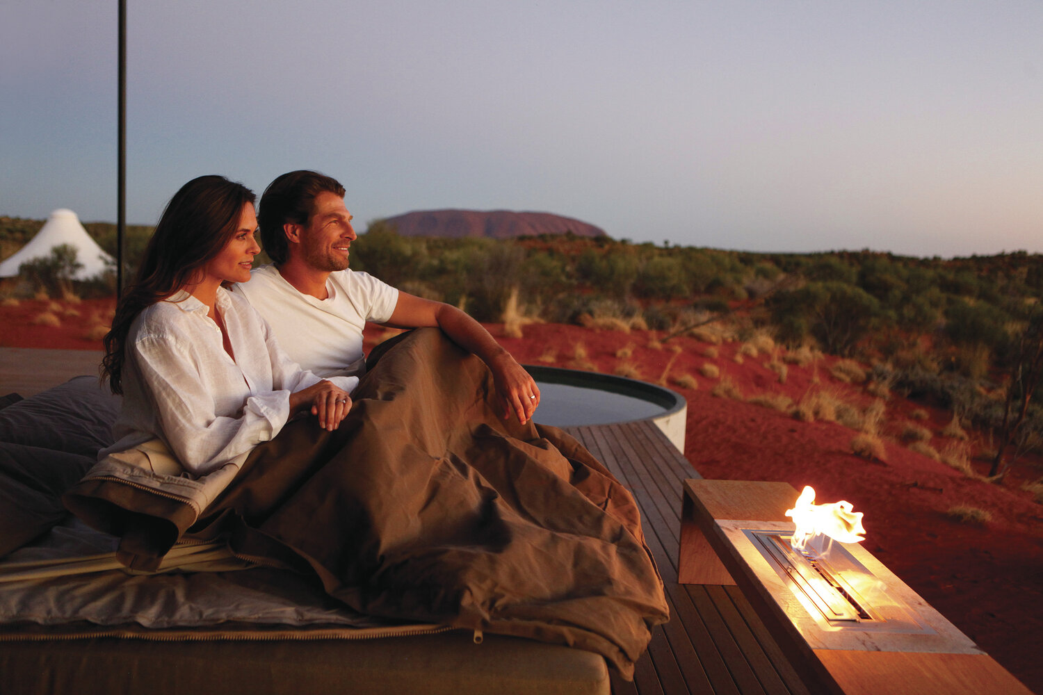 Ehepaar sitzt am Lagerfeuer am Uluru
