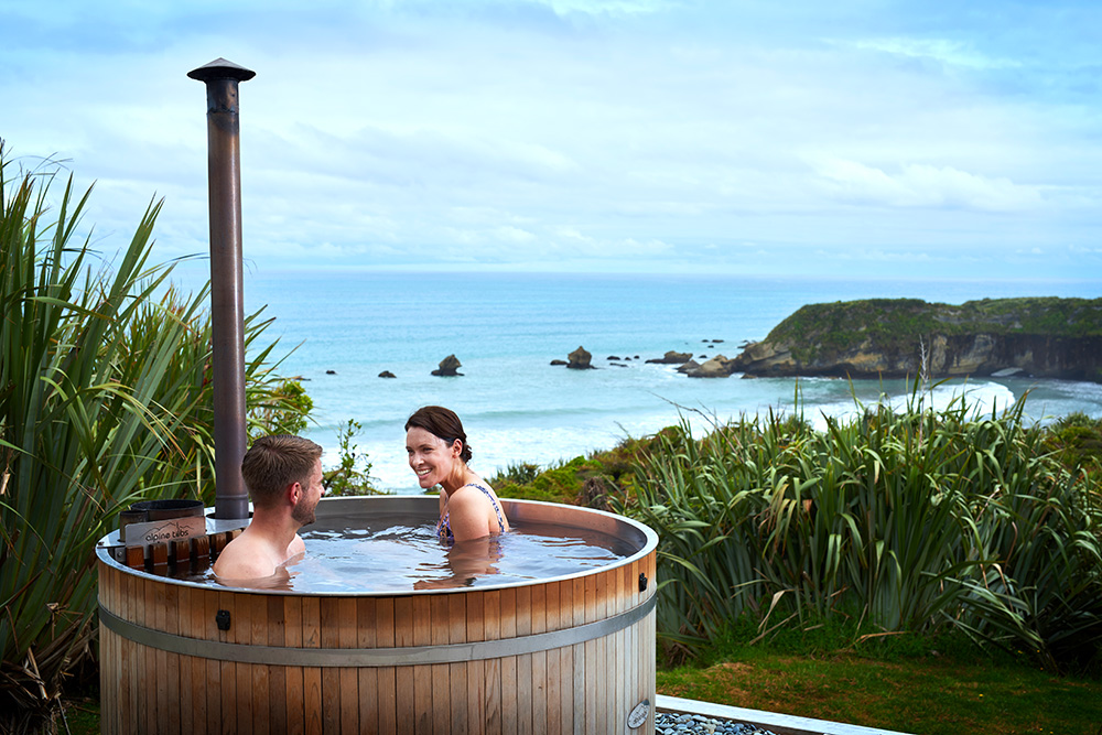 Couple Outdoors In Hot Tub With View of Ocean, Dreamaroo New Zealand.