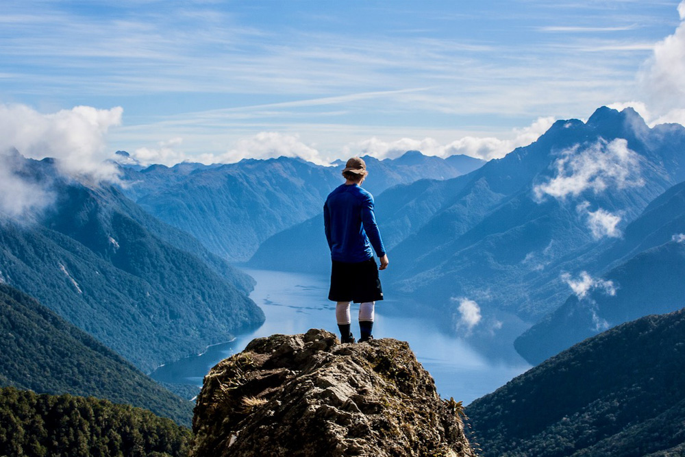 Man Standing On Rock Facing Vast Mountain and River View, Dreamaroo New Zealand.